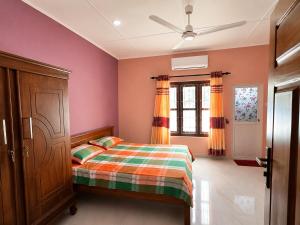 a bedroom with a bed and a ceiling fan at JB Vin Hotel in Point Pedro