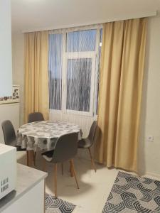 a dining room with a table and chairs and a window at Апартамент Централ in Targovishte