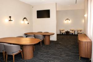 a waiting room with wooden tables and chairs at FORTINN Puerta del Sol in Madrid
