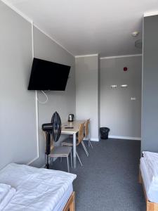 a bedroom with a desk and a table with chairs at Hostel Guido in Zabrze