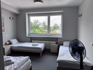 a room with two beds and a fan in it at Hostel Guido in Zabrze +39 photos
