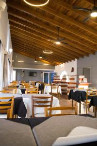 a dining room with tables and chairs and wooden ceilings at Paraiso Termal in Federación