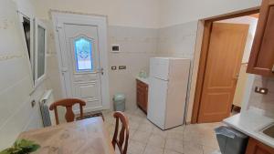 a kitchen with a white refrigerator and a table at Emerald House in Augusta in Augusta +5 photos