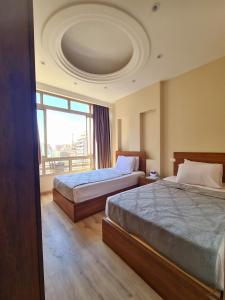 a hotel room with two beds and a large window at suites in cairo downtown in Cairo