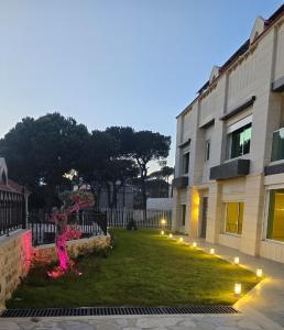 a building with a statue in the grass next to a building at Villa K تلة الصنوبر in Ḩāşbayyā