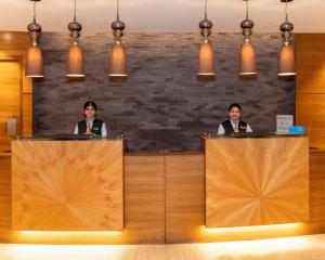 two women are standing behind podiums in a lobby at Hyatt Raipur in Raipur
