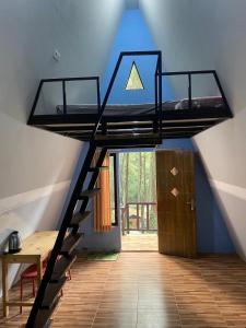 a room with two bunk beds and a wooden table at The Nest Park in Prigen