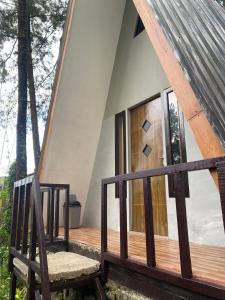 a wooden porch with a chair on a house at The Nest Park in Prigen