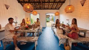 a group of people sitting at tables in a restaurant at Pousada Caraíva in Caraíva