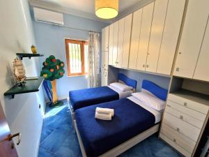 a bedroom with a blue bed and white cabinets at Casa Alexandr Piedigrotta in Pizzo