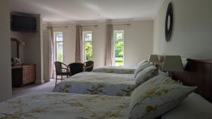 a bedroom with two beds and a table and chairs at Applecroft House in Killarney