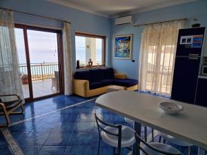 a living room with a couch and a table with chairs at Casa Alexandr Piedigrotta in Pizzo