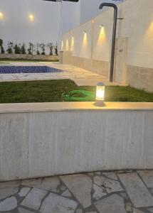 a light sitting on a wall next to a pool at Villa K تلة الصنوبر in Ḩāşbayyā