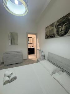 a white bedroom with a bed and a mirror at Il gingillo di Alice by Maniel Beach Hotel in Letojanni