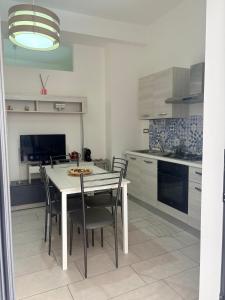 a kitchen with a table and chairs in a kitchen at Il gingillo di Alice by Maniel Beach Hotel in Letojanni