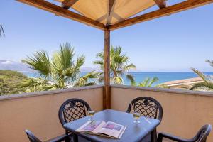 a table and chairs on a balcony with a view of the ocean at Casa Onda Azzurra in Balestrate
