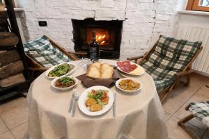 a table with plates of food and a fireplace at Casa Natura Gargano in Monte SantʼAngelo