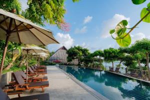 a pool at a resort with chairs and umbrellas at Phi Phi Phu Chalet Resort in Phi Phi Islands