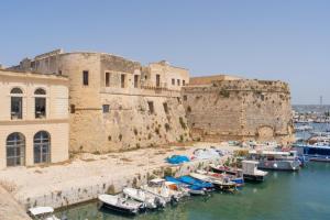 a group of boats in a harbor next to a castle at Dimore di Matilde - Romantic Suite in Gallipoli