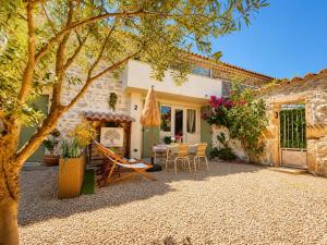 a patio with a table and chairs in front of a house at La Bohème Mouriès in Mouriès