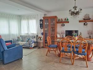a living room with a table and chairs at Villa Eucaliptus Lloret de Mar in Vidreres