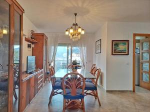 a dining room with a table and chairs and a chandelier at Villa Eucaliptus Lloret de Mar in Vidreres