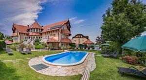 a large house with a swimming pool in the yard at Fortuna Villa in Hévíz
