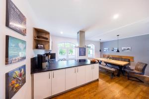 a kitchen with a table and a dining room at Ferienhaus Bimmelbahn 2 - Familienferienhaus 100 m am Dampflokbahnhof Sauna Trampolin Spielezimmer in Olbersdorf