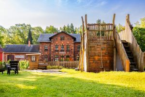 a house with a wooden fence and a wooden staircase at Ferienhaus Bimmelbahn 2 - Familienferienhaus 100 m am Dampflokbahnhof Sauna Trampolin Spielezimmer in Olbersdorf
