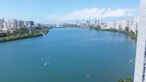a river with boats in the middle of a city at Ritz Condo in San Juan