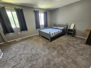a bedroom with a bed and two windows at Cozy place! in Baltimore