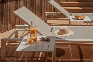 a table with glasses and a bottle of orange juice at Moulin de Longuecoste, 11 couchages, Nature, Rivière, Piscine et Pool House in Montet-et-Bouxal