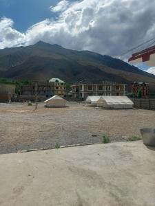 two tents in a parking lot in front of a building at The Dupchen Cave View in Kaja