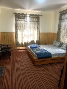 a bedroom with a large bed in front of a window at The Dupchen Cave View in Kaja