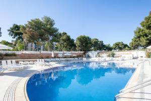 a swimming pool with white chairs and blue water at Inter 2 in Salou