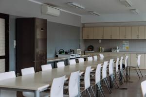 a conference room with a long table and white chairs at Hostel Guido in Zabrze