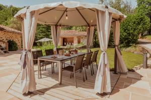 a table under an umbrella on a patio at Moulin de Longuecoste, 11 couchages, Nature, Rivière, Piscine et Pool House in Montet-et-Bouxal