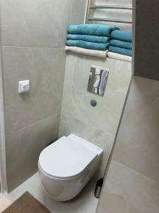 a white toilet in a bathroom with towels at Apartamentai Kelmėje in Kelmė