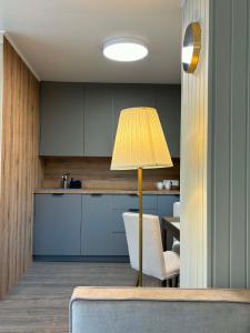 a kitchen with a table and a lamp in a room at Apartamentai Kelmėje in Kelmė