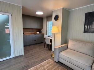 a living room with a couch and a kitchen at Apartamentai Kelmėje in Kelmė