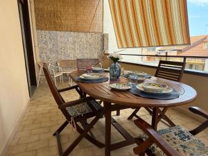 a wooden table with plates of food on a balcony at Da Nonna Maria in Roccalumera +4 photos