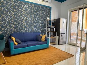 a blue couch in a living room with a wall at Da Nonna Maria in Roccalumera
