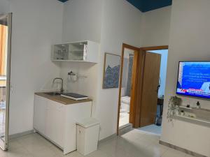 a kitchen with a sink and a tv on a wall at Da Nonna Maria in Roccalumera