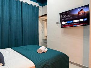 a bedroom with a bed with a tv on the wall at Da Nonna Maria in Roccalumera