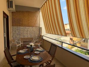 a dining room with a table and chairs and a balcony at Da Nonna Maria in Roccalumera