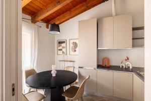 a small kitchen with a black table and chairs at Lodge Fiera Milano in Rho