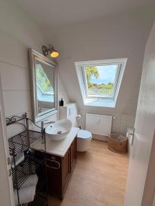 a bathroom with a sink and a toilet and two windows at HYGGE HOMES - Apartment 'hyggehus' in Lüneburg +35 photos