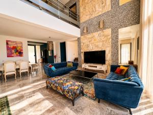a large living room with blue couches and a television at Villa Solis Elegant Villa with Private Pool in La Marsa
