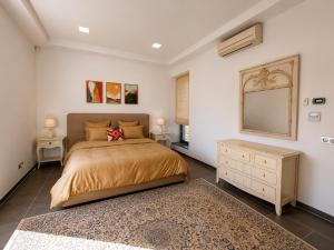 a bedroom with a bed and a dresser and a mirror at Villa Solis Elegant Villa with Private Pool in La Marsa