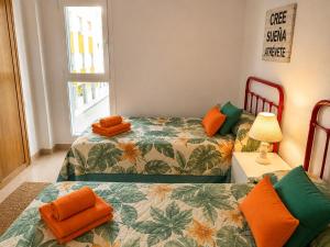 two beds with orange pillows in a room at Velez Nazari Cambriles in Lújar